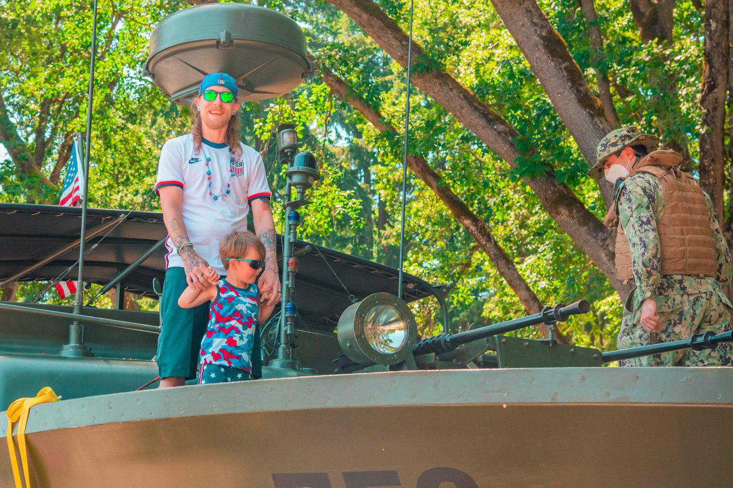 Dustin and his son Lukas sport red, white, and blue attire while standing on a Vietnam Era PBR boat at Borst Park Sunday afternoon in Centralia during Summerfest.